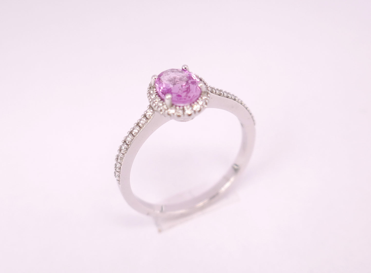 Bague saphir rose entourage diamants, monture pavée de diamants, or blanc 18 carats.