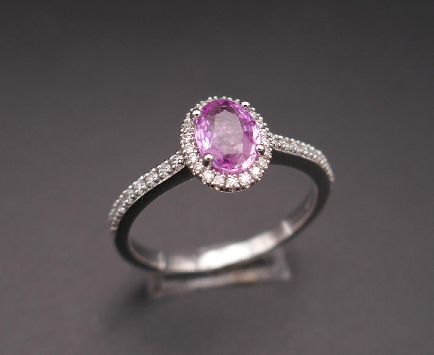 Bague saphir rose entourage diamants, monture pavée de diamants, or blanc 18 carats.